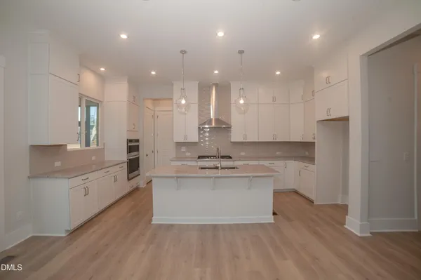a large kitchen with kitchen island a sink stainless steel appliances and cabinets