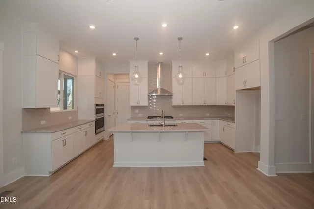 a large kitchen with kitchen island a sink stainless steel appliances and cabinets
