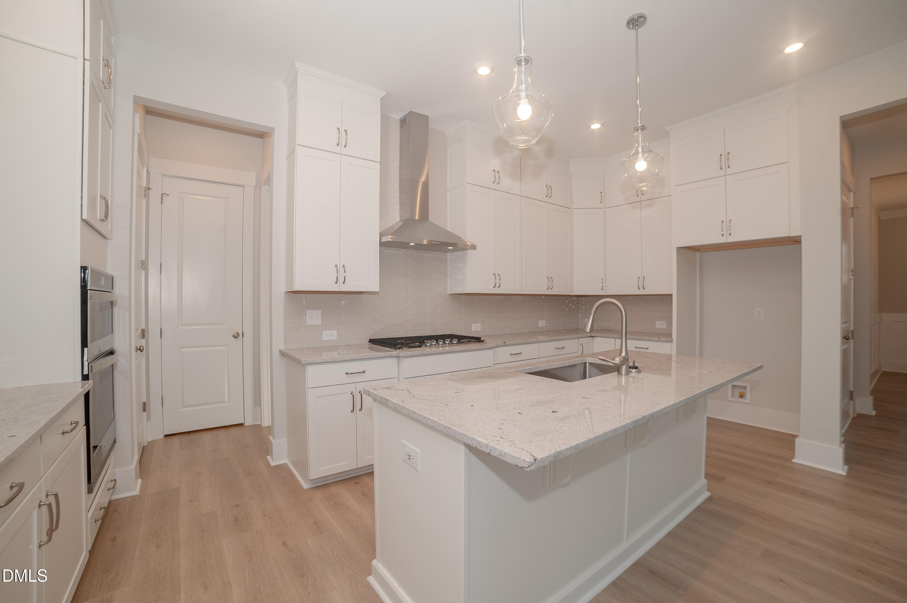 2 Wolf Tree Way Efland, NC 27243 - Photo 7 of 29 a kitchen with a stove a sink a refrigerator and white cabinets with wooden floor