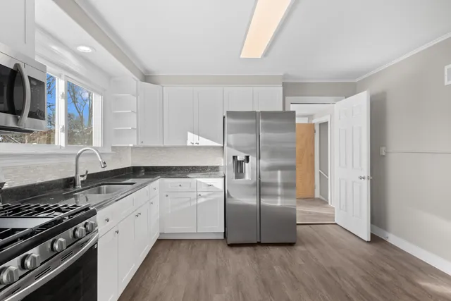 a kitchen with granite countertop a refrigerator stove and sink