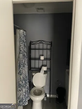 a bathroom with a toilet and a shower curtain