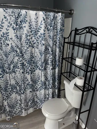 a white toilet sitting next to a shower