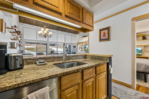a kitchen with stainless steel appliances granite countertop a sink and a refrigerator