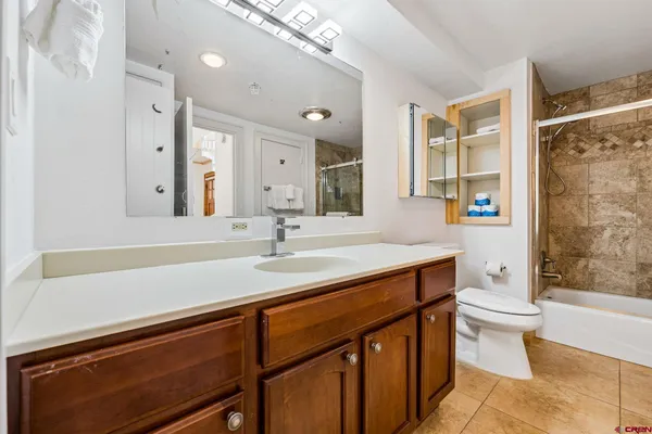 a bathroom with a sink a toilet a mirror and shower