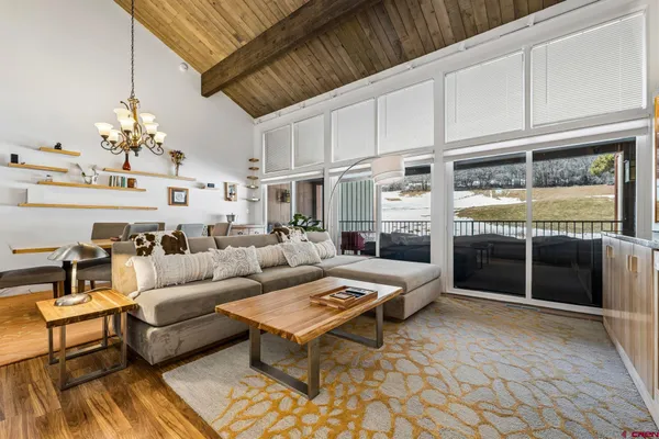 a living room with furniture a chandelier and a rug