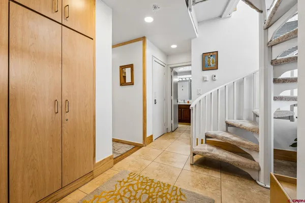 a view of a hallway with a livingroom with furniture and stairs