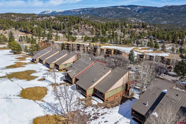an aerial view of a house with a mountain
