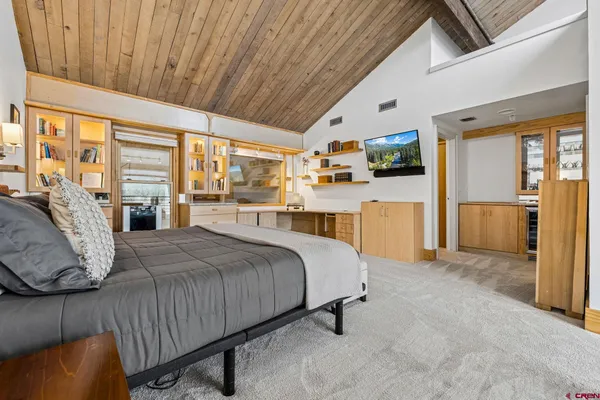 a spacious bedroom with a bed and large windows