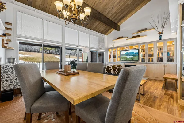 a view of a dining room with furniture a chandelier and wooden floor