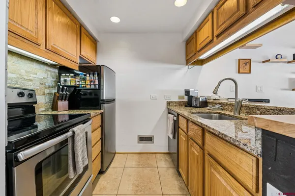 a kitchen with stainless steel appliances granite countertop a sink and cabinets