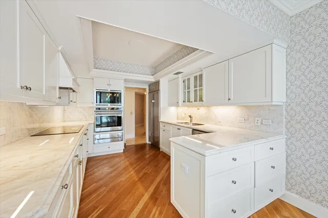 a kitchen with granite countertop white cabinets and white appliances