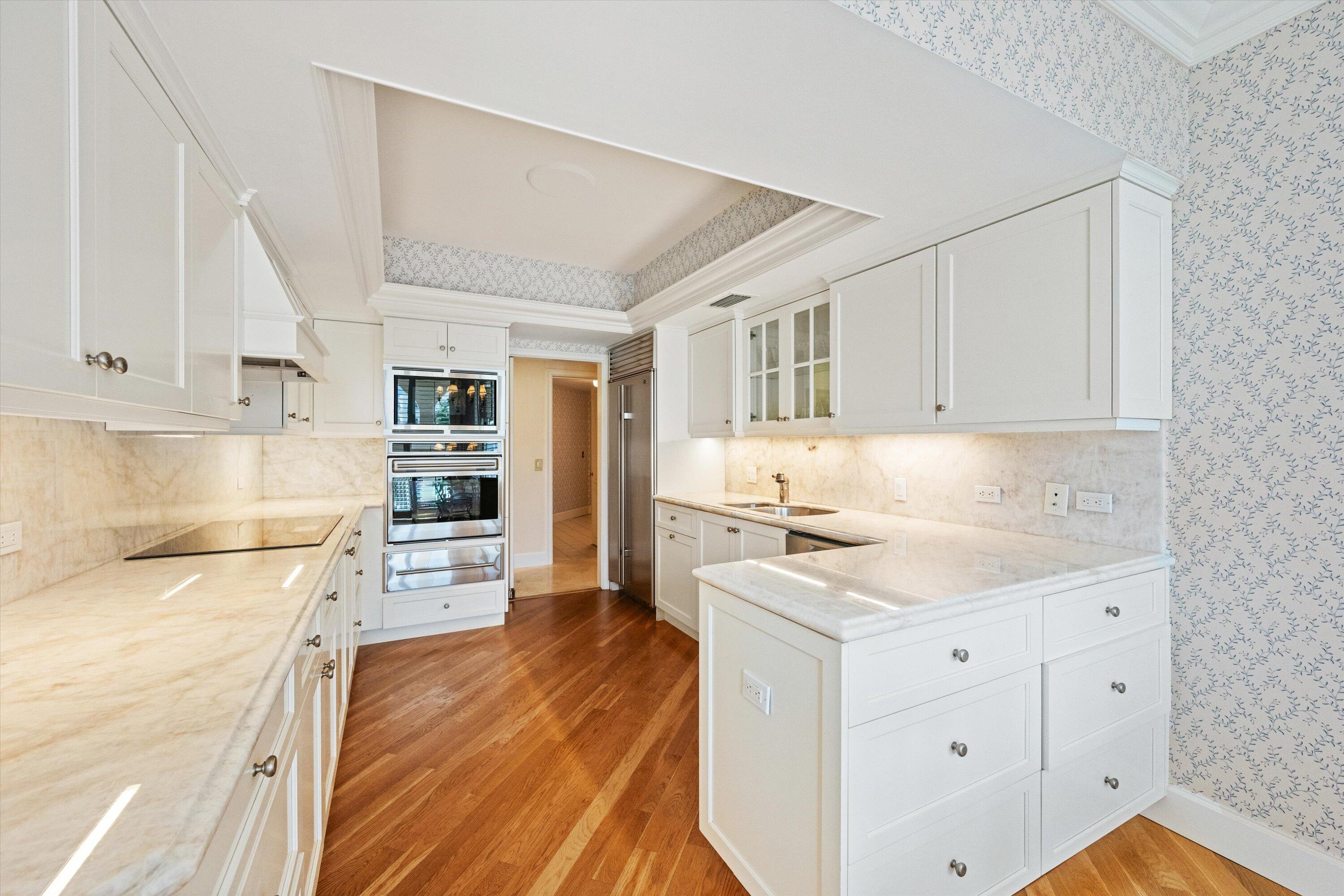 200 Bradley Place, Unit 303 Palm Beach, FL 33480 - Photo 11 of 40 a kitchen with granite countertop white cabinets and white appliances