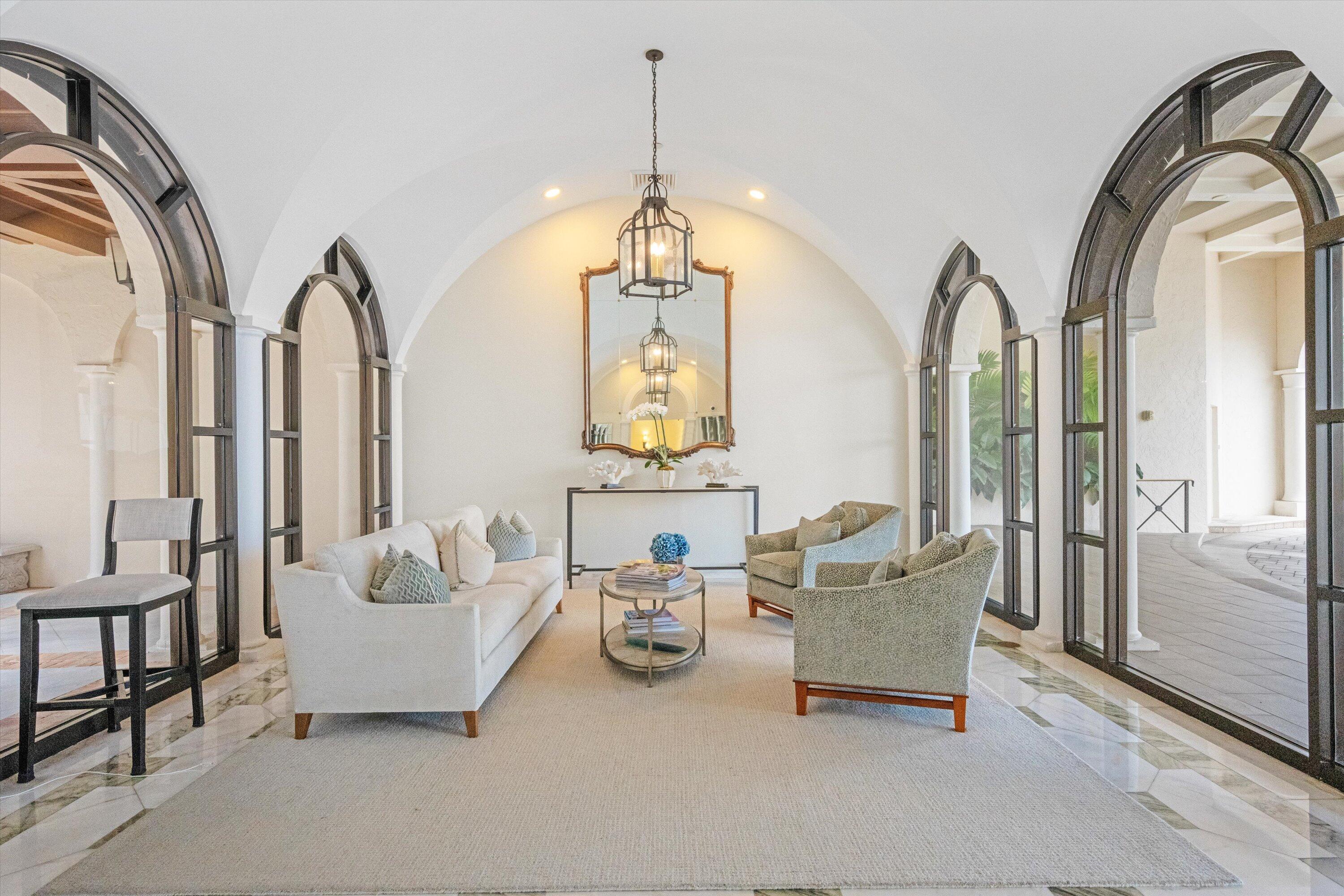 200 Bradley Place, Unit 303 Palm Beach, FL 33480 - Photo 28 of 40 a living room with furniture and a chandelier