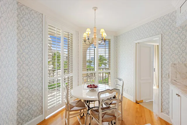 a dining room with furniture a chandelier and wooden floor