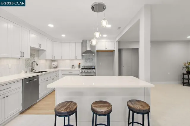 a kitchen with stainless steel appliances a table and chairs in it