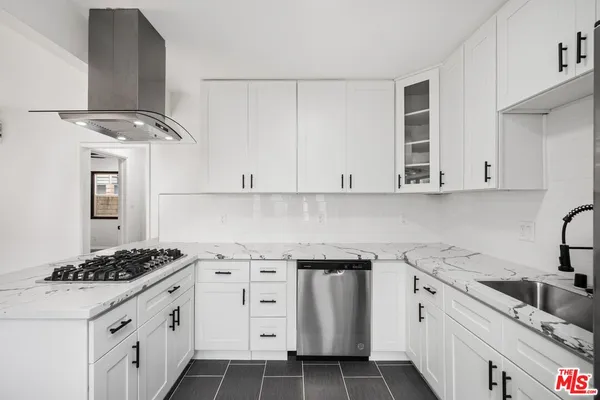 a kitchen with granite countertop a sink stove and cabinets