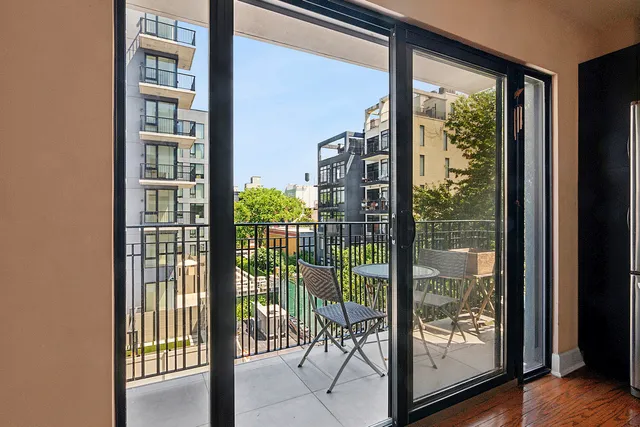 a kitchen with kitchen island granite countertop wooden floor a refrigerator a sink and a stove