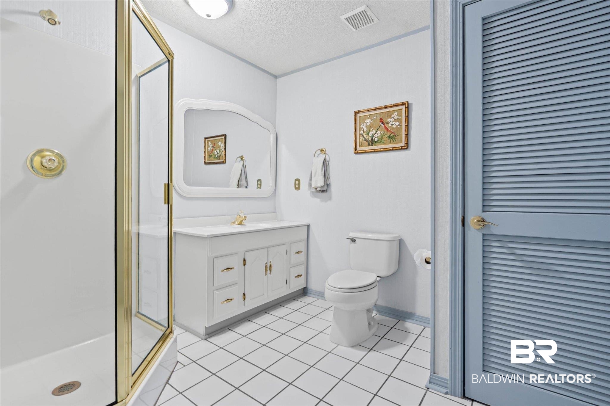 1900 Foxfire Road Mobile, AL 36618 - Photo 17 of 36 Full bathroom featuring light tile patterned floors, a stall shower, vanity, a textured ceiling, and a closet