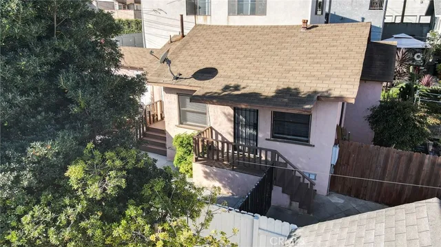 an aerial view of a house with a yard and a large tree