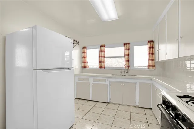 a kitchen with stainless steel appliances a refrigerator sink and cabinets