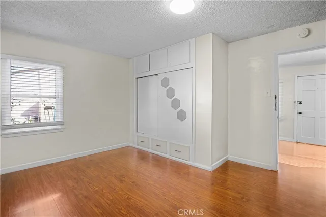 an empty room with wooden floor and window