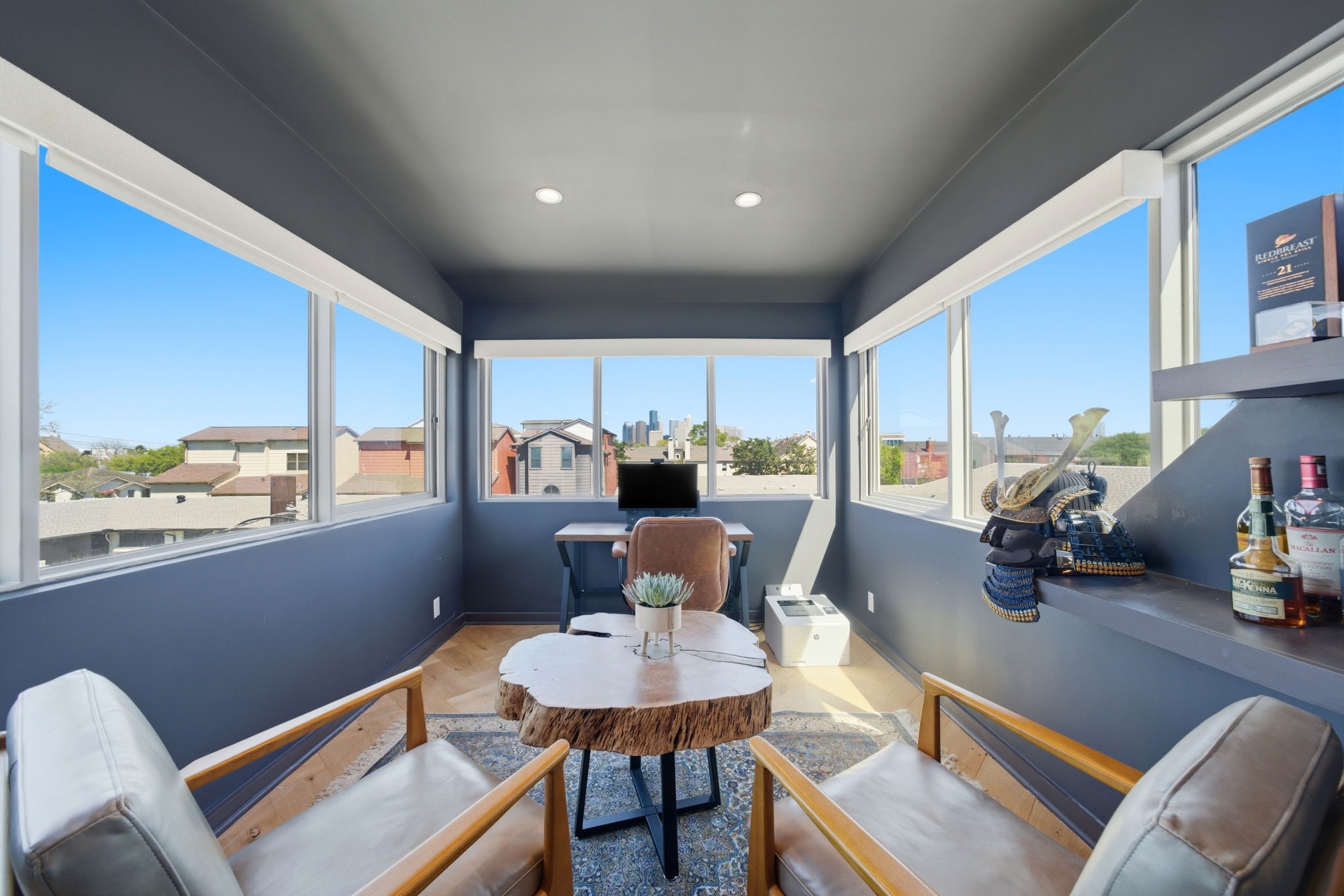2615 Yupon Street Houston, TX 77006 - Photo 13 of 50 Light-filled second-floor study offers a premier vantage point with expansive gridded windows framing panoramic views of the Downtown Houston skyline. Sophisticated charcoal walls and warm wood flooring create a focused environment, while the generous layout easily accommodates a workspace and a separate lounge area. Elevated by its architectural lines and prime Inner Loop location, this retreat blends professional functionality with urban luxury.