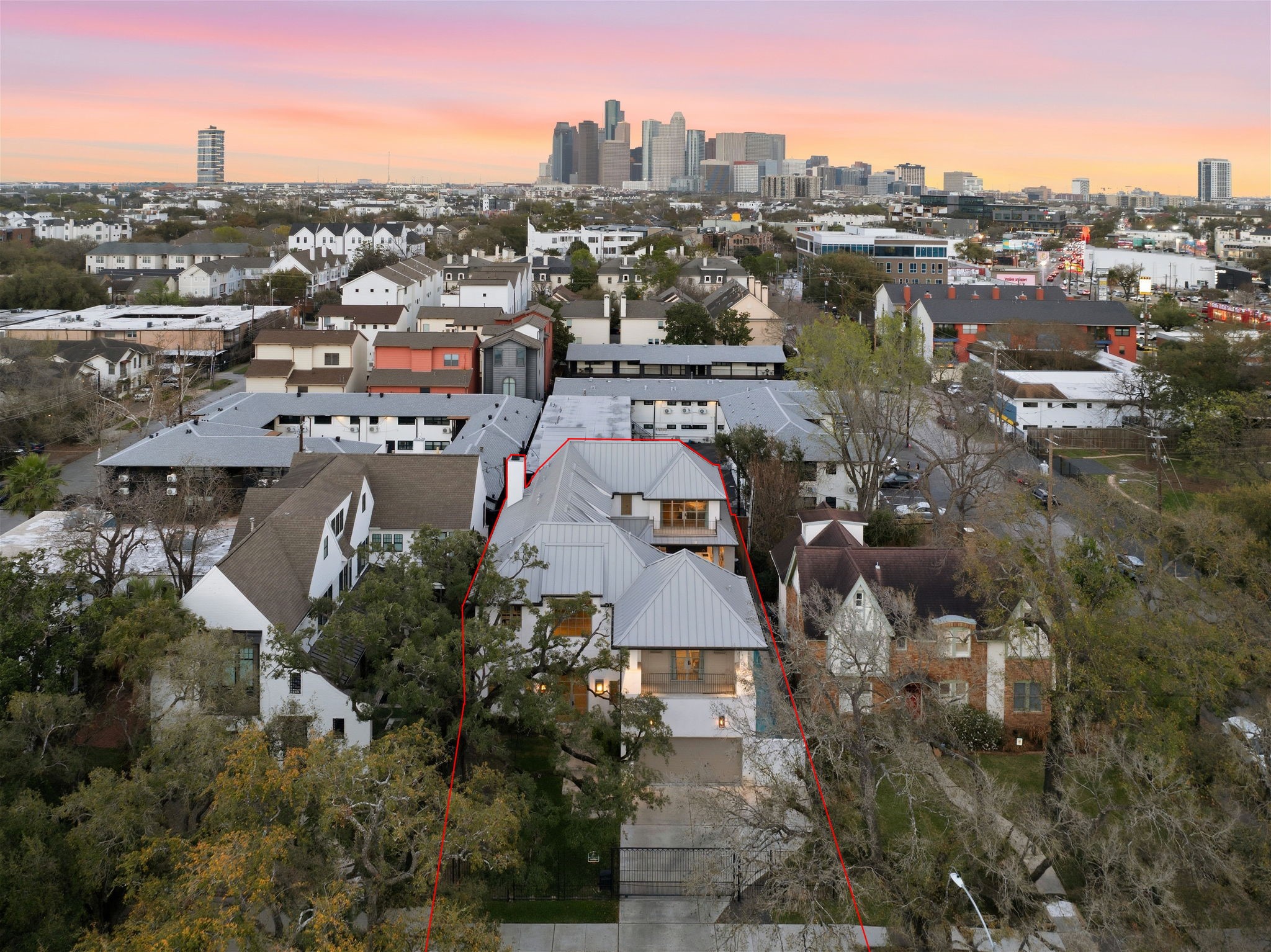 2615 Yupon Street Houston, TX 77006 - Photo 6 of 50 Situated at 2615 Yupon St, this 2022 custom estate commands a prime position with breathtaking views of the Downtown Houston skyline. The striking architectural profile features a sleek metal roof and multiple private balconies, nestled among large canopy trees on a picturesque Montrose street. A secure gated driveway leads to the 3-car garage, offering privacy and luxury in a premier Inner Loop location.