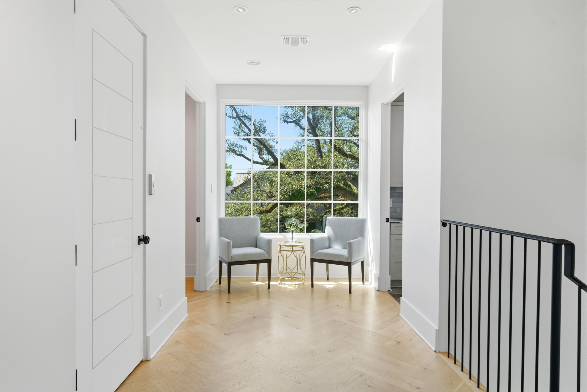 2615 Yupon Street Houston, TX 77006 - Photo 10 of 50 Grand foyer features elegant architectural details, including a cascading crystal chandelier and durable stone tile flooring. Steel and glass doors offer glimpses into the dedicated study and mudroom, while the wide hallway flows effortlessly toward the light-filled main entertainment areas. Refined neutral tones and clean lines define this 2022 custom estate’s sophisticated entry.