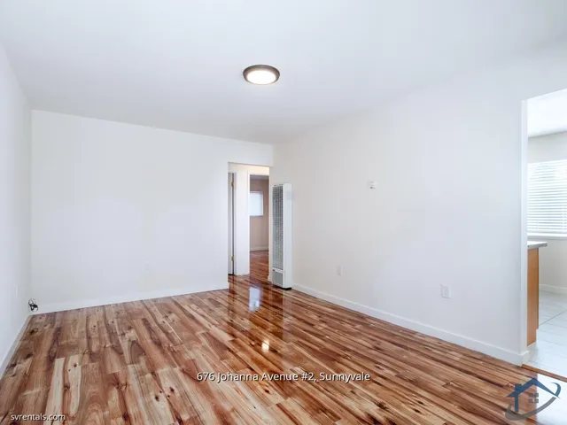 a view of a room with wooden floor and white walls