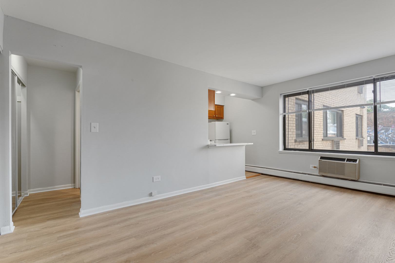 6758 North Sheridan Road, Unit 247 Chicago, IL 60626 - Photo 2 of 13 a view of an empty room with wooden floor and a window