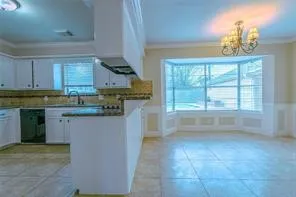 a kitchen with kitchen island granite countertop a stove a sink and a microwave