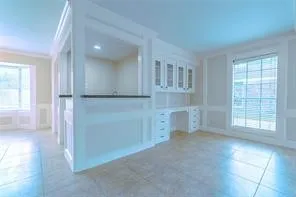 an empty room with windows and cabinet