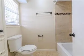 a white toilet sitting next to a bath tub