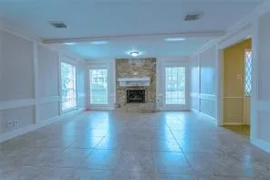 an empty room with windows and fireplace