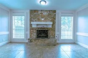 an empty room with windows and fireplace