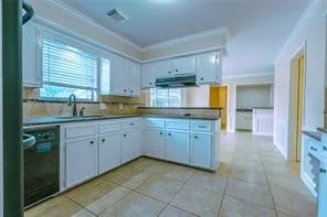 a kitchen with a sink window and cabinets