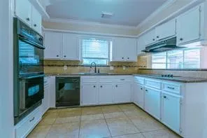 a kitchen with granite countertop cabinets stainless steel appliances and a sink