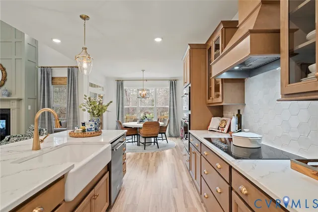 a dining hall with stainless steel appliances kitchen island granite countertop a sink and wooden floor