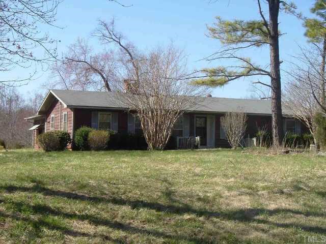 a front view of a house with yard and trees