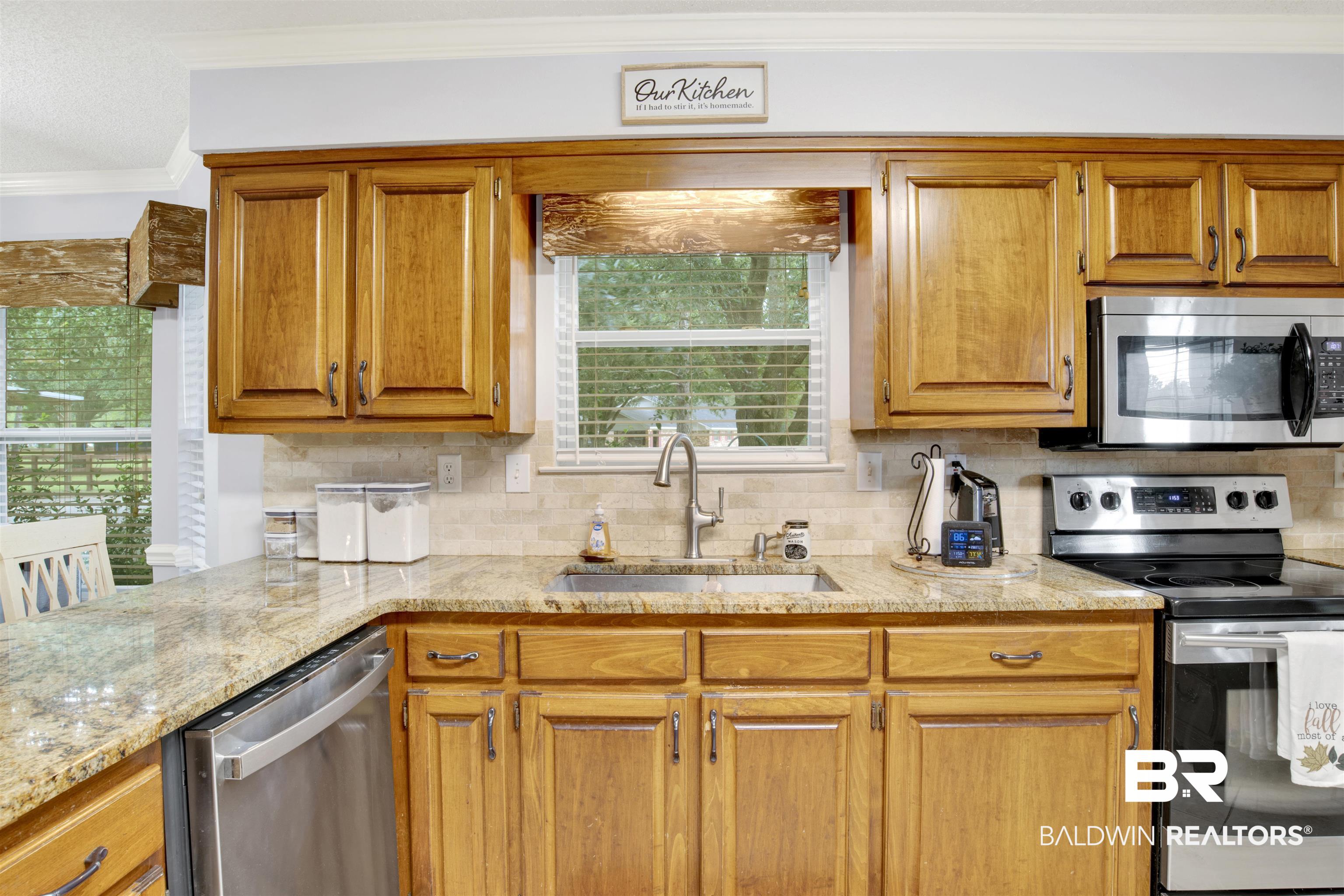 13385 Tom Gaston Road Mobile, AL 36695 - Photo 12 of 42 Kitchen with light stone counters, ornamental molding, sink, tasteful backsplash, and appliances with stainless steel finishes