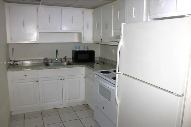 a kitchen with white cabinets and white appliances