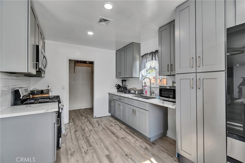 5121 Sierra Street Riverside, CA 92504 - Photo 16 of 34 a kitchen with white cabinets stainless steel appliances and sink