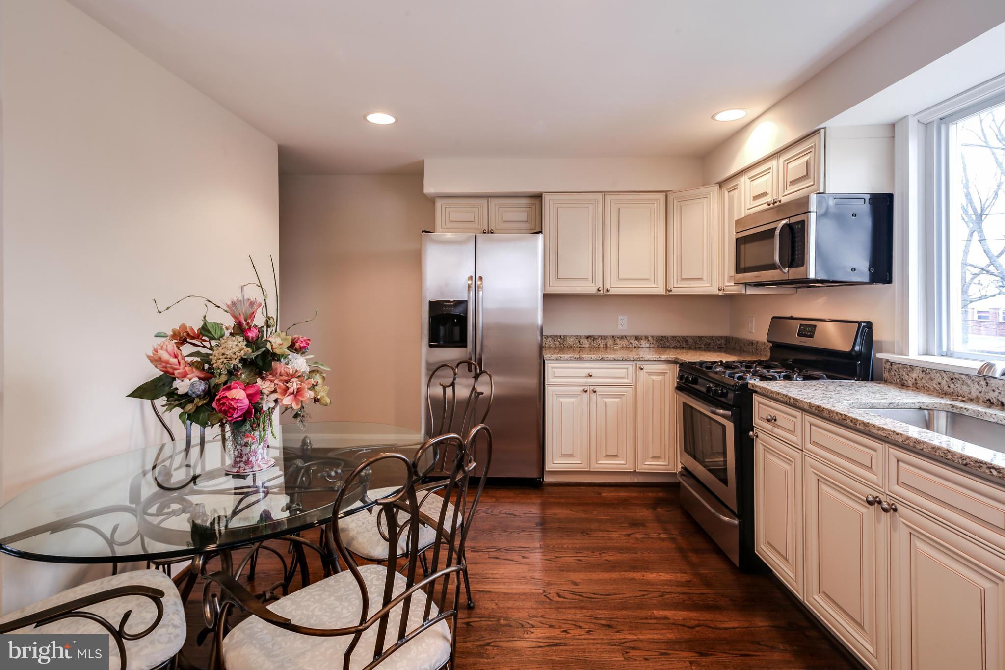 1315 Deanwood Road Baltimore, MD 21234 - Photo 6 of 30 a kitchen with stainless steel appliances granite countertop a refrigerator a stove a sink dishwasher and white cabinets with wooden floor