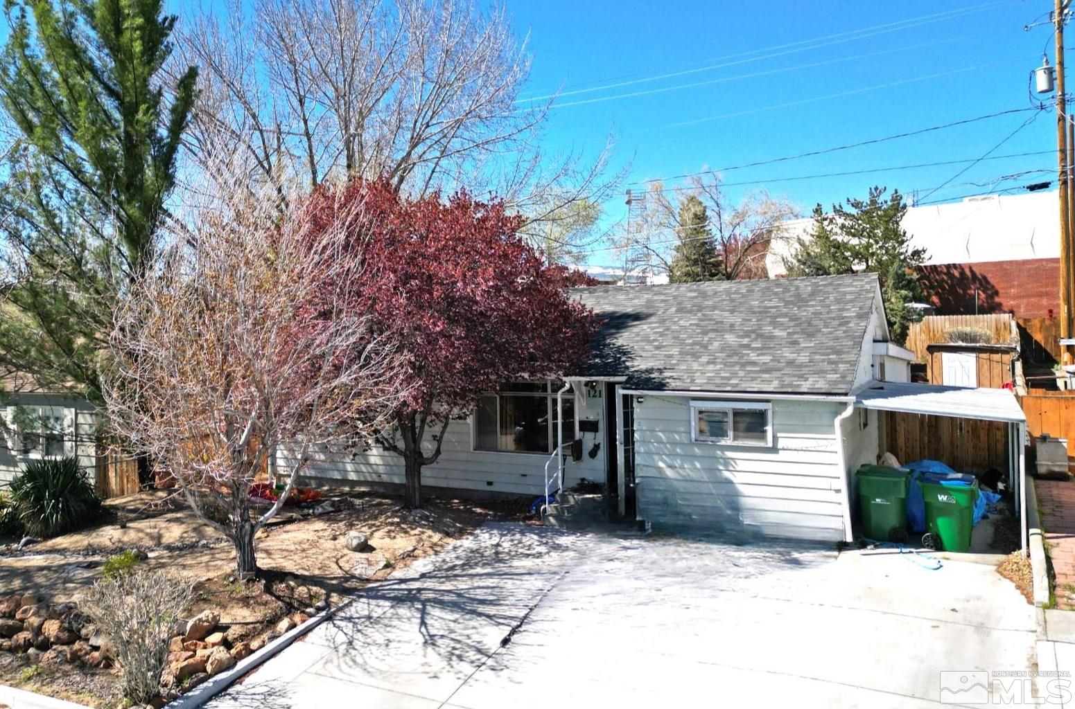 a backyard of a house with large trees and outdoor seating