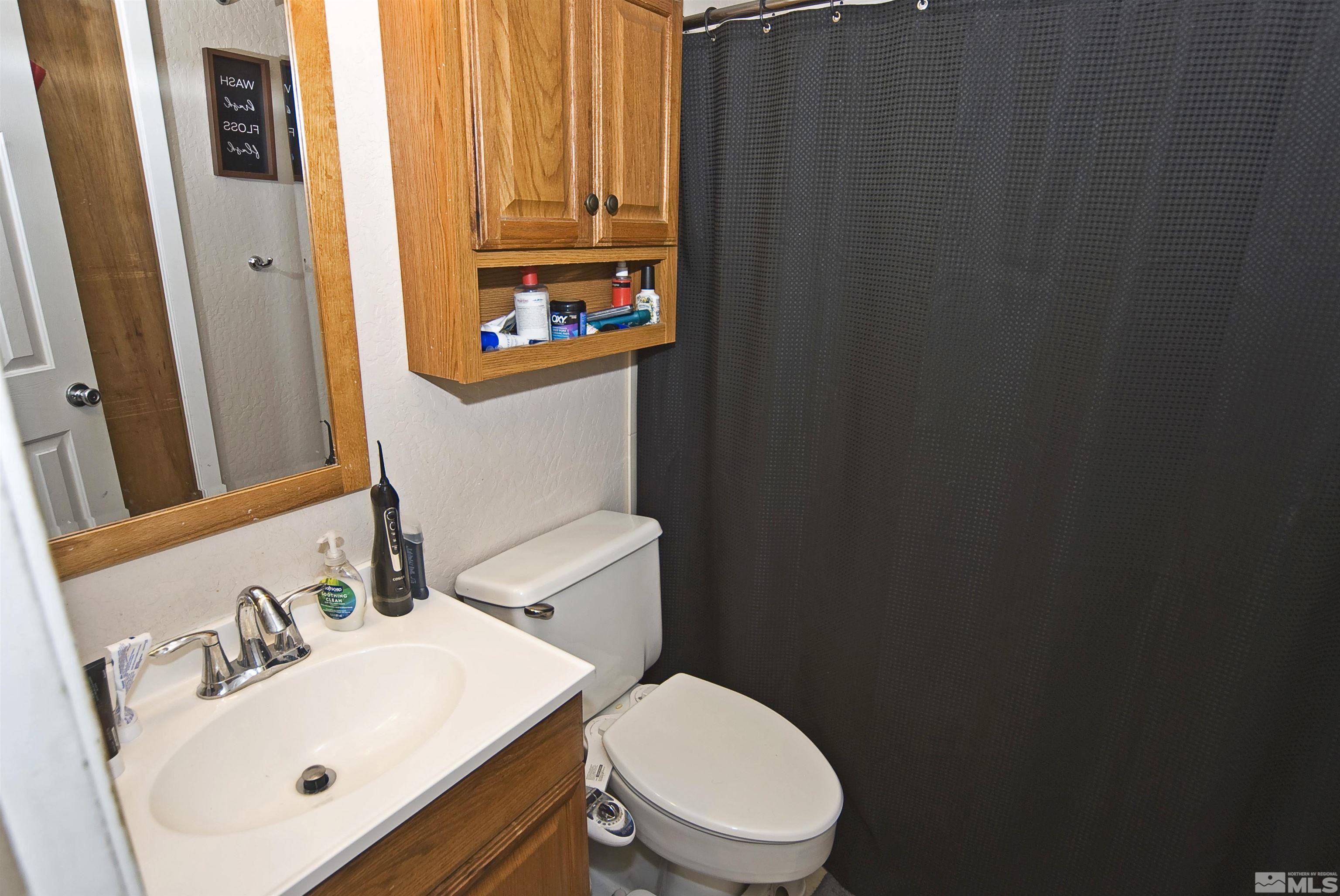 121 Bartlett Street Reno, NV 89512 - Photo 8 of 27 a bathroom with a sink a toilet and shower curtain