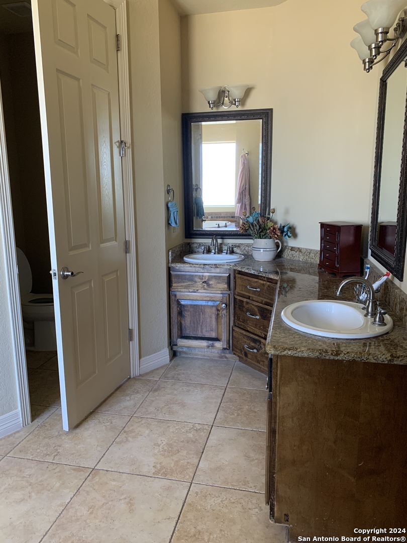 338 Tower Road San Antonio, TX 78223 - Photo 14 of 26 a bathroom with a sink a toilet and mirror