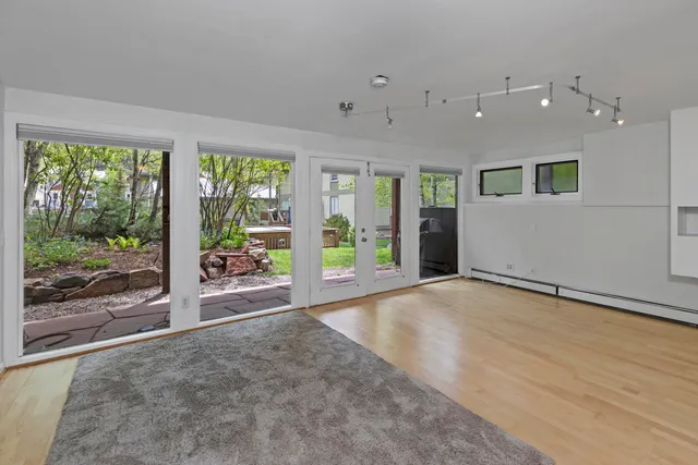 a view of a big room with wooden floor and windows