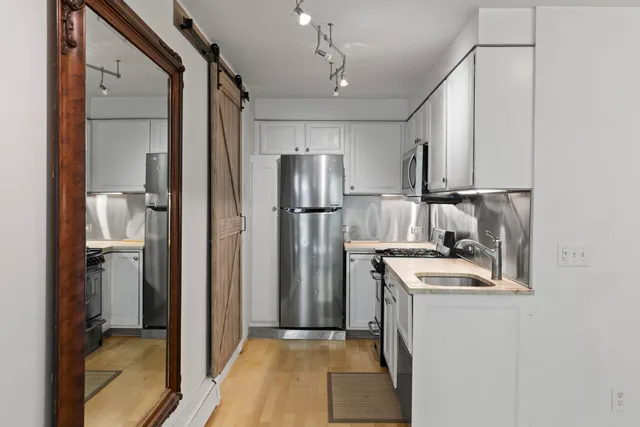 a kitchen with stainless steel appliances granite countertop a refrigerator and a stove