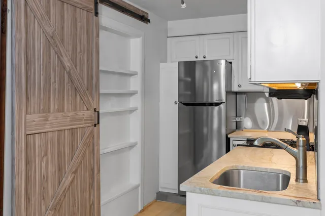 a kitchen with a refrigerator and cabinets