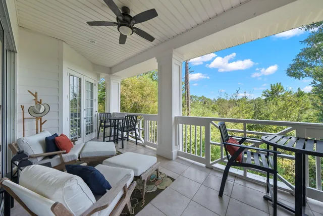 a living room with furniture a chandelier and a floor to ceiling window